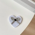 Macro view of heart-shaped portable makeup mirror with glitter and bow decoration - Starry Silver Foil Bow #6 / White