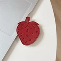 Detail of red leather strawberry phone grip with fine stitching on a modern white desk - Burgundy