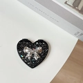 Detail of a heart-shaped portable mirror with silver glitter and a 3D metallic bow - Starry Silver Foil Bow #5 / Black