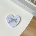 Close-up of a purple heart-shaped portable mirror with glitter and a silver metal bow - Starry Silver Foil Bow #7 / White
