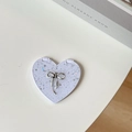 Close-up of heart-shaped purple portable makeup mirror with sequins and silver bow decoration - Starry Silver Foil Bow #4 / White
