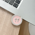 Détail du support téléphone rose avec perles et nœud argenté sur fond en bois - Style Adhésif Transparent - Noeud en Perle Ronde / Rose