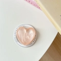 Dettaglio del supporto per telefono a forma di cuore rosa pesca con finitura perlata - Arancione Luccicante