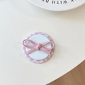 Détail du support de téléphone à nœud rose avec texture de ruban sur fond blanc - Film à Carreaux Nœud Diagonal Magnétique / Rose