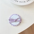 Detail of a purple plaid phone socket with a fabric bow on a clean white table - Checkered Film Magnetic Diagonal Bow / Purple