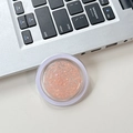 Close-up of glitter sequins for phone socket accessory in round peach orange container - Orange