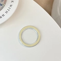Macro detail of clear and pale yellow MagSafe magnetic ring on a minimalist white table - Transparent - Yellow Edge