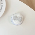 Dettaglio di un supporto per telefono in peluche bianco con farfalla di strass - Orso di peluche con strass / Bianco