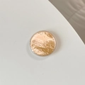 Detailansicht der Handyhalterung in Champagnergold mit Knitteroptik unter glänzendem Harz - Orange