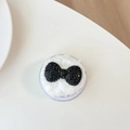 Macro shot of luxury black rhinestone bow phone grip with white plush cushion detail - Plush Rhinestone Round Bowknot / Black