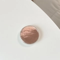 Macro shot of rose gold round phone socket with metallic crinkle texture on white background - Brown