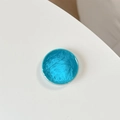 Macro detail of round bright blue phone grip with textured diamond-cut surface pattern - Sky Blue