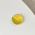 Close-up of a round yellow gold foil container with textured metallic finish on white back - Yellow