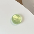 Macro shot of circular light green phone grip with unique water ripple textured surface - Light Green