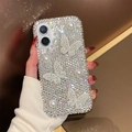 Detailed view of luxury iPhone case with silver rhinestones, pearls, and butterfly charms - Iridescent / iPhone 16e