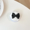 Close-up of black rhinestone butterfly phone grip with plush white faux fur base - Plush Rhinestone Flat Bowknot / Black