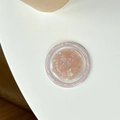 Primer plano de un soporte circular para móvil con textura de concha rosa irisada - Marrón Colorido