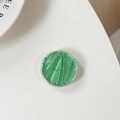 Detalle macro de soporte para móvil redondo verde claro con papel plata y textura - Verde Esmeralda