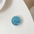 Detailed view of round ice blue phone grip with silver foil glitter and crackle texture - Light Blue