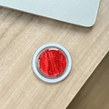 Makro-Detail des roten Glitzer MagSafe Handy-Griffs auf einem Holz-Schreibtisch - Magnetische Epoxid-Silberfolie-Wasserwelle / Kirschrot