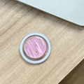 Dettaglio del supporto MagSafe magnetico con glitter rosa su una scrivania in legno - Onde d'Acqua in Resina Epossidica Magnetica a Fogli d'Argento / Rosa