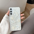 Detail of 3D starfish and pearl decorations on glittery white phone case - Samsung A14 / Cat's Eye Sea Star