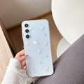 Detalle macro de funda azul con purpurina, mariposas 3D blancas y cuentas plateadas - Perla de Plata Mariposa de Jade Blanco / Samsung A14