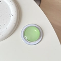 Macro detail of a lime green hemispherical magnetic phone grip with white Magsafe base - Light Green
