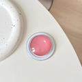 Detailed top view of a pink crystal glass MagSafe phone grip on a white minimalist desk - Bean Paste Red