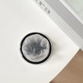 Detalle del soporte magnético de pata de gato gris transparente sobre escritorio blanco - Negro