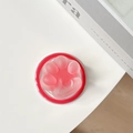 Close-up of pink translucent cat paw MagSafe phone holder with heart detail on white background - Red