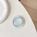 Detail of light green crystal glass MagSafe phone grip with minimalist round design - Milky Green