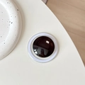 Detail of minimalist black crystal glass magnetic phone grip with a white outer ring - Black