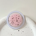 Detail view of round pink magnetic phone grip with glitter particles on a ceramic plate - Magnetic Morandi Ink Splash Pink