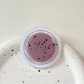 Detailed top view of purple exfoliating lip balm with fine particles in a round clear jar - Magnetic Morandi Ink Splash Purple
