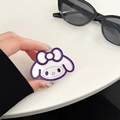Detail of purple acrylic My Melody mirror phone grip held over a clean white desk - White Bracket-Style B Line Beauty Mirror / Dark Purple