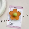 Macro detail of orange leather flower phone grip with green bead on pink card - (Magnetic) 3D Leather Flower - Golden Brown