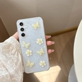 Dettaglio di farfalle 3D gialle e fiori bianchi su cover per telefono azzurra glitter - Samsung A14 / Farfalla Fiore di Ciliegio Giallo-Bianco con Foglia d'Argento