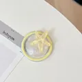 Detalle del soporte móvil de estrella de mar amarilla con resina brillante en blanco - Estrella de Mar Perlada Redonda Magnética / Amarillo