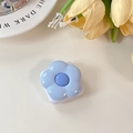 Close-up of a light blue flower-shaped phone grip and vanity mirror on a desk - Blue
