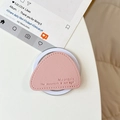 Detailed shot of pink leather triangle phone socket with embossed mountain quote texture - Pink