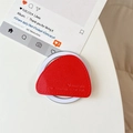 Detail of red leather triangular magnetic phone grip with fine stitching and embossed text - Red