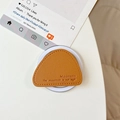 Macro detail of brown leather magnetic phone socket with lychee grain and mountain embossed - Gold Brown