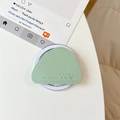 Macro shot of light green triangular leather phone stand with mountain embossing - Green
