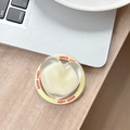Detail of transparent heart phone grip with yellow 'GOOD LUCK' rim on a laptop - Magnetic Sandwich Heart / Yellow