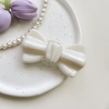 Detail of pearlescent white bow phone grip holder with fine glitter and heart-shaped base - Large Bowtie Stand-Pearl-White