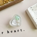 Dettaglio del supporto per telefono a cuore con stelle e perle su sfondo pelle - Supporto Adesivo - Stella Blu Verde