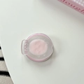 Nahaufnahme der rosa Handy-Halterung mit geprägtem Gesicht auf weißem Tisch - Rosa
