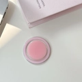 Vue macro d'un support de téléphone magnétique rond rose sur un bureau blanc épuré - Magnétique-Rose