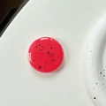 Macro shot of translucent cherry red resin phone socket with black flecks and glossy finish - Coral